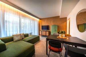 een woonkamer met een bank en een tafel bij goldfinger + suites in Lana