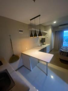 a living room with a white table and a bench at Studentpark apartment by RD in Yogyakarta