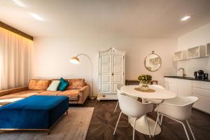 een woonkamer met een bed en een tafel bij goldfinger + suites in Lana