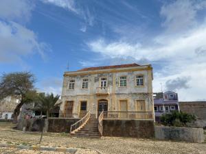 Un edificio antiguo con una escalera en el frente. en A casa do amor, en Vila do Maio