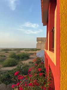 a red and yellow building with flowers on the side at A casa do amor in Vila do Maio