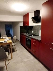 a kitchen with red cabinets and a table with chairs at Südeifel Spangdahlem in Spangdahlem +21 photos