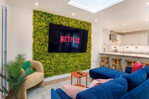 a living room with blue couches and a green wall at Abbotsford House sleeps 8 in York