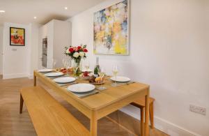 a dining room table with plates and flowers on it at Abbotsford House sleeps 8 in York