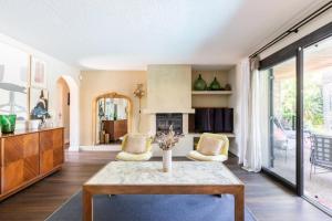 een woonkamer met een tafel en een open haard bij Villa Baccarat in Porto-Vecchio +15 foto's