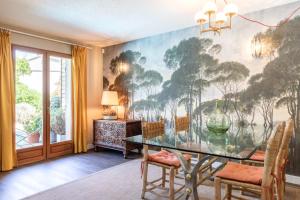 een eetkamer met een groot schilderij aan de muur bij Villa Baccarat in Porto-Vecchio