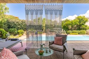 een terras met een tafel en stoelen en een zwembad bij Villa Baccarat in Porto-Vecchio