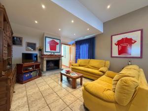 sala de estar con sofá amarillo y TV en Casa Rural Bardenas Park, en Carcastillo 19 fotos más