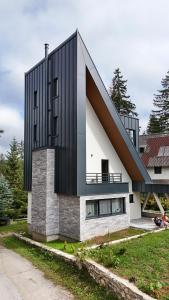 a house with a black and white facade at Viva Vlasic - Apartman i vikendica in Šišava