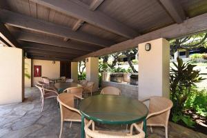 a row of tables and chairs on a patio at Kaanapali Royal A303 · KRL A303 Relaxing Hawaiian 2BD on Golf Co in Lahaina