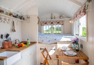 a kitchen with a table and a bed in a room at The Shepherds Hut at Anvil House in Woodbridge