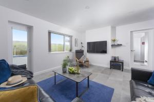 een woonkamer met een bank en een tafel bij 10 The Valley - Free Parking & WiFi, Close To Beaches in Porthcurno