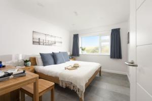 een slaapkamer met een bed en een raam bij 10 The Valley - Free Parking & WiFi, Close To Beaches in Porthcurno
