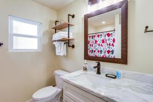 a bathroom with a toilet and a sink and a mirror at 8 Mi to Dtwn New Orleans! Newly Renovated Home in Metairie +17 photos