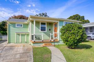 a green house with a porch and a driveway at 8 Mi to Dtwn New Orleans! Newly Renovated Home in Metairie