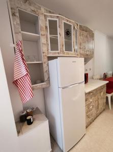 a kitchen with a white refrigerator and wooden cabinets at Cuibul Practic in Oradea