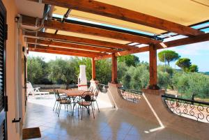 a patio with a table and chairs under a wooden pergola at Recidence Villa Olivia in Itri