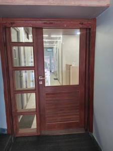 a wooden door with a mirror in a room at Vilva Premium Multi Sharing Rooms in Madurai
