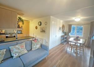 un soggiorno con un divano blu e un tavolo di Clear Sky Lodge Park a Falstone