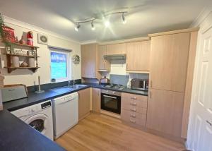una cucina con lavatrice e lavastoviglie di Clear Sky Lodge Park a Falstone