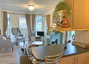 una cucina e un soggiorno con tavolo e sedie di Clear Sky Lodge Park a Falstone