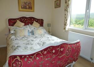 un letto rosso in una camera da letto con finestra di Clear Sky Lodge Park a Falstone