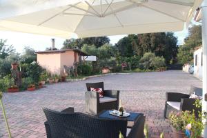 a patio with chairs and a white umbrella at B&B La Terrazza di Frascati in Frascati