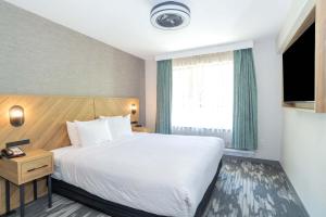 a hotel room with a bed and a window at Sandman Signature Surrey-Guildford Suites in Surrey