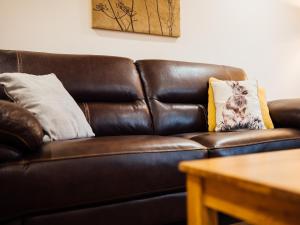 The Barn في Girthon: أريكة جلدية بنية مع وسادتين عليها