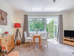 Una sala de estar con una mesa y una ventana. en Black Hill View, en Manaton