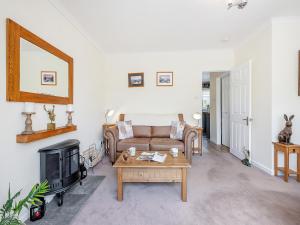 Una sala de estar con un sofá y una chimenea. en Black Hill View, en Manaton