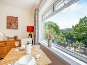 Un comedor con una mesa y un gran ventanal. en Black Hill View, en Manaton 15 fotos más