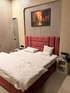 Un dormitorio con una cama grande con cabecero rojo. en Homyana stays, en Jāmb