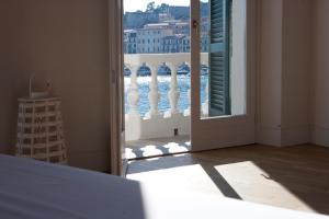 eine offene Tür zu einem Balkon mit Blick auf das Wasser in der Unterkunft Porto Sole Rooms in Portoferraio
