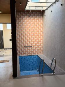 Una bañera azul en una habitación con una pared. en Homyana stays, en Jāmb