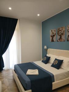 a bedroom with a king sized bed with blue walls at boutique teatro b&b in Foggia