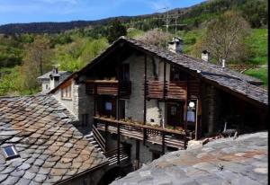 una vecchia casa con balcone in un villaggio di Maison di Viola a Arliod