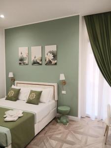 una camera da letto con un letto e una parete verde di boutique teatro b&b a Foggia