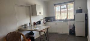 a small kitchen with a table and a refrigerator at HartebeesDen in Worcester