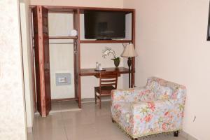 a living room with a chair and a desk at Hotel Aloha Managua in Managua