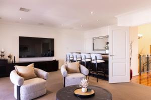 a living room with a group of chairs and a table at The Iluka Mirage - Sauna - Spa - Heated Pool - Fire pit - 5BR in Perth