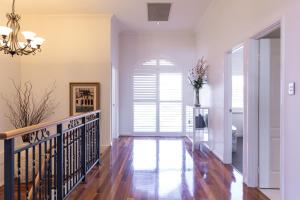 a hallway of a home with a staircase and a window at The Iluka Mirage - Sauna - Spa - Heated Pool - Fire pit - 5BR in Perth