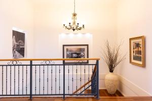 a hallway with a staircase with a chandelier at The Iluka Mirage - Sauna - Spa - Heated Pool - Fire pit - 5BR in Perth +36 photos