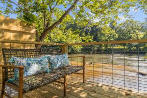 a bench on a deck with a view of a field at Laurel Bush Combo - 6 Waterfront Homes, Fish, Hike, and Mountain Views! in Sylva