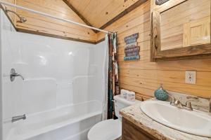 a bathroom with a tub and a sink and a toilet at Tuck River Magic - 6 Waterfront Homes, Fish, Hike, and Mountain Views! in Dillsboro +52 photos