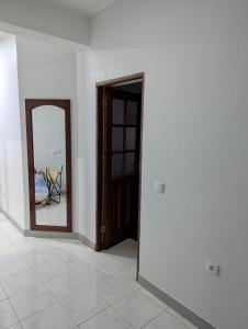 Cozy 3 Bdr at Praia Da Laginha في منديلو: غرفة فارغة فيها باب ومرآة