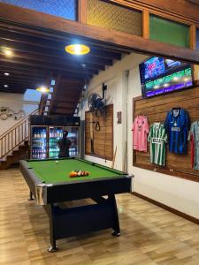 a billiard room with a pool table and a tv at Uncle Matts Cafe and Chill in Chiang Mai
