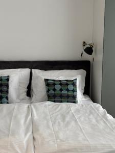 een bed met witte lakens en kussens in een slaapkamer bij Apartmány Zlatý Potok in Zvolen