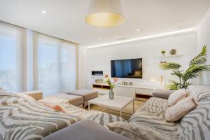 een woonkamer met een bank en een tv bij Casa Reiet by dracmallorca in Santanyi