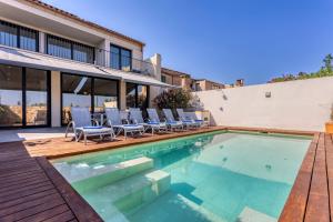 een zwembad met stoelen en een huis bij Casa Reiet by dracmallorca in Santanyi
